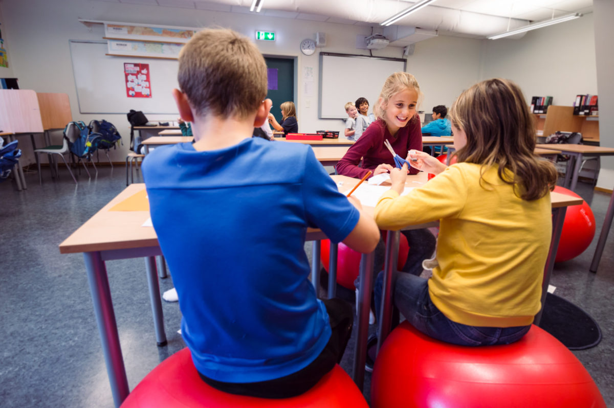 barn i klasserom som smiler